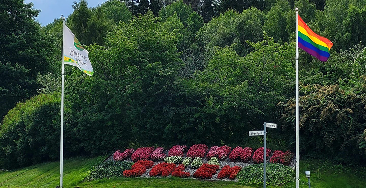 Pappa och två barn plockar skräp vid vattnet